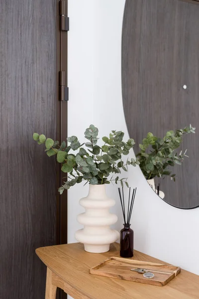 木のテーブルの上に現代的なインテリアデザイン ユーカリの枝とセラミック花瓶 香りスティックとキーとの玄関口の詳細 — ストック写真