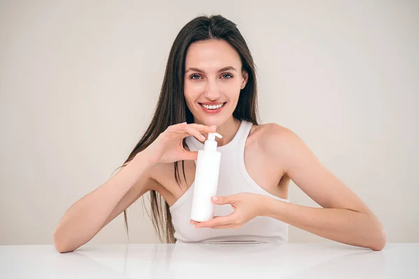 Ung Kvinna Visar Dispenser Flaska Med Fuktighetskräm Och Skämma Bort — Stockfoto