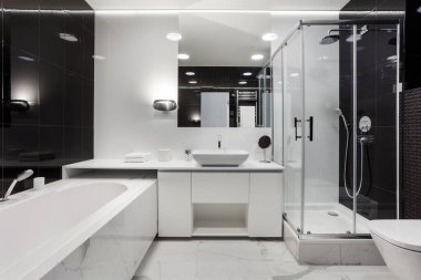 Modern iç mekan otel banyosu, cam kapılı duş kabini, banyo küveti, lavabo lavabosu, lavabo dolabının altı ve yerdeki mermer döşeme.