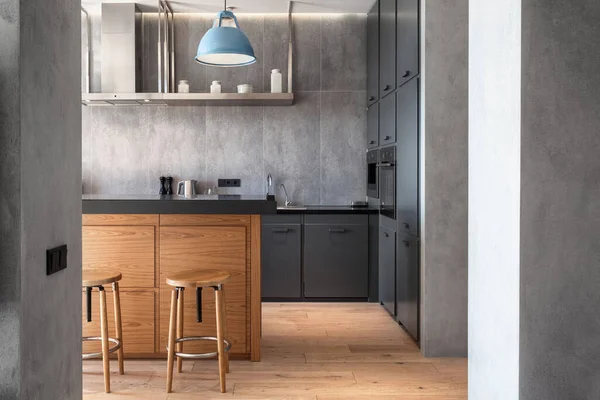 フラットスタジオでモダンなインテリアデザインのキッチン 木製のバースツールとグレーのテクスチャの壁とキャビネットの家具 — ストック写真