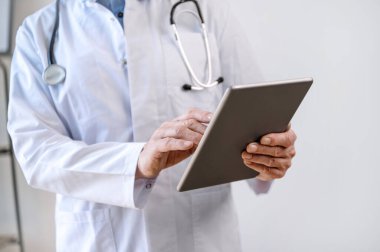 Modern dijital tablet taşıyan olgun bir doktorun hastayla uzaktan iletişim kurmak için sağlık uygulamasını kullanması. İlaç reçetesi, online danışma konsepti