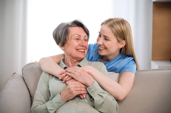Medical care. Nurse or volunteer social worker hug with happy patient, looking to each other. Concept of healthcare or physiotherapy. Charity, caregiver support at nursing home for elderly people