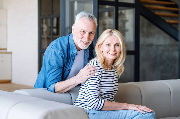 Lächelnd Umarmt Der Erwachsene Ehemann Seine Frau Auf Dem Sofa — Stockfoto