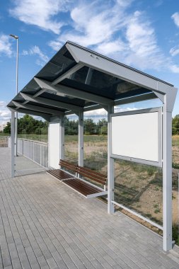 Toplu taşıma istasyonundaki ticari reklamlar için şablon şehir ışık kutusu. Ahşap banklı otobüs durakları, koruyucu cam duvarlar ve pazarlama promosyonları için boş reklam panoları.