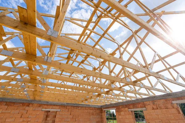 Beams, lumbers and joint planks on roof installation, low angle view. Support elements of wooden framework, construction site, concepts of process of building a new home