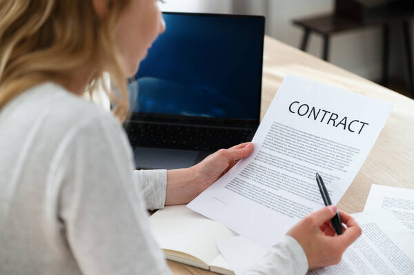 Manager thoughtfully reading contract for financing new project. Analyzing terms and conditions for marketing campaign. Notice important information in documents.