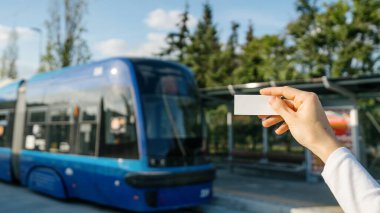 Bulanık platform arka planına karşı seyahat için turist eliyle seçmeli tren biletine odaklan. Modern taşımacılıkta rahat bir yolculuk. Boşluğu kopyala.