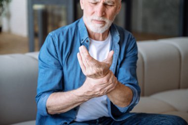 Sağlık ve sorun konsepti. Kolunda ağrı olan, bileğine dokunan son sınıf öğrencisi. Romatoid eklem iltihabı. Eklem ağrısı, osteoartrit hastalığı.