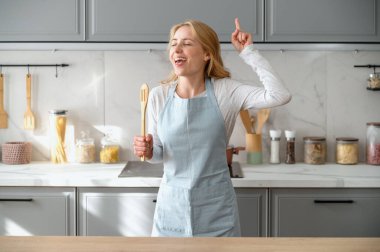 Ahşap kaşık tutan, şarkı söyleyen, modern mutfakta tek başına duran yetenekli genç bir kadın tasasız bir hafta sonu geçirir. Önlüklü ev hanımı en sevdiği hobiyi sever. Karaoke ve eğlence kavramı