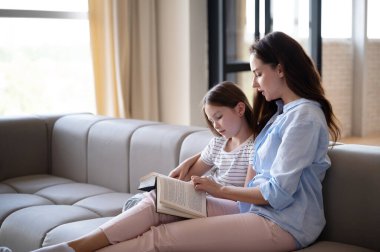 Birlikte kitap okuyoruz. Hafta sonunu evde geçirmek. Şefkatli, sevgi dolu bir anne anaokulu çocuğunu kucaklıyor, ilginç bir peri masalı anlatıyor. Çocuk eğitim kavramları