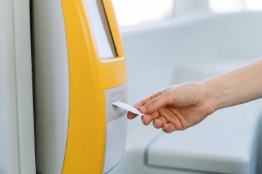 Ulaşım kavramı. Toplu taşıma için sahte kağıt bilet onaylayan bir kadın. Otobüste, tramvayda, trende, tramvayda otomatik okuyucu teknojisi