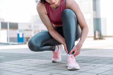 Spor koşu bileği burkulması. Sporcu kadının acı veren burkulmuş vücuduna dokunuşu. Atletizm antrenmanı kazası. Kadın dışarıda egzersiz yaptıktan sonra bacağında ağrı hissediyor..