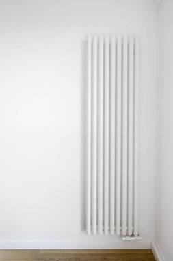 Modern radyatörlü dikey çekim kış mevsiminde evi ısıtmak için beyaz duvara monte edildi. Çağdaş dairede bireysel iklim kontrol sistemi. Ev ısıtıcısı ekipmanı tasarımı