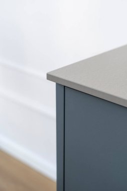Mavi mutfak dolabına yakın plan ve gri tezgah. Modern apartmandaki dolapta masanın üst kısmının köşesi. Minimalist tarzda mobilyalar. Detaylar iç kısımda