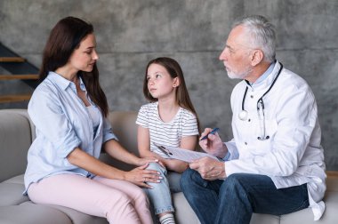 Tıbbi kayıtları olan bir doktor, ateşi olan bir çocuk için reçete ve tedavi planı, ev ziyaretinde küçük bir hastanın annesiyle konuşmak. Üzgün çocuk hasta olduğu için annesine bakıyor, çocuk tavsiyesi dinliyor.