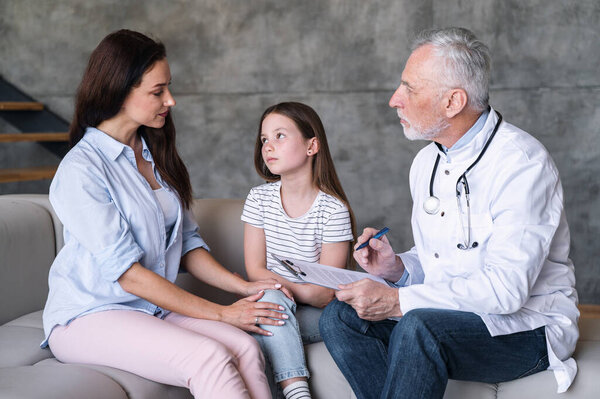 Врач с медицинскими записями, рецептом и планом лечения ребенка с лихорадкой, поговорить с мамой маленького пациента на дому. Грустный ребенок из-за болезни, глядя на мать, прислушиваясь к детскому совету