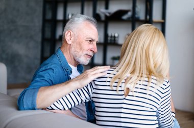 Yaşlı bir adam zor durumdaki bir kadına destek olur. Evdeki kanepede oturup partnerini taşımak, dikkatlice dinlemek ve eşinin ya da arkadaşının duygularını anlamak.