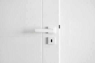 Metal sapı ve beyaz arka planda anahtar deliği olan modern kapı tasarımı. Çağdaş dairede iç mekan elementi. Oturma odasında giriş. Gizlilik kavramı