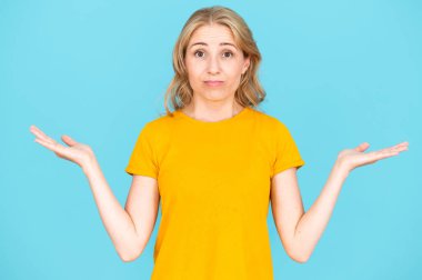 Avuç içleriyle hareket eden şüpheli bir kadın, seçeneklerin seçimi, zor satın alma kararı. Teklif alanı, reklam ve mavi arkaplan anlaşması için kopyala