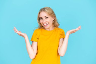 Mavi stüdyo arka planında izole gülümseyen kadın el ele tutuşup iki seçeneği karşılaştır. Mutlu olumlu kadın seçimi. Teklif, reklam ve anlaşma için alanı kopyala