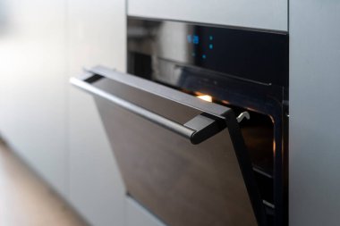 Modern elektrikli fırın mutfak dolabına entegre edildi. İçinde ışık ve kapı olan pişirme ekipmanları. Sapı seçmeye odaklan. Yemek pişirmek için ev aletleri