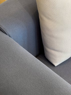 Oturma odasında beyaz yastıklı gri koltuğun koltuk rafına seçici bir şekilde odaklan. Yumuşak mobilyalar için yapılmış yeni tekstil döşemeleri olan koltuk ya da kanepenin manzarasını kapat. Kuru temizleme servisi kavramları