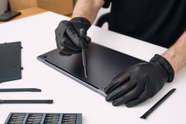 Adam dizüstü bilgisayarı söküyor. Garanti servisi, veri kurtarma ve onarım konseptleri. Profesyonel işçi broker bilgisayarında kapak açtı, elektronik aygıtı tamir etti, eski parçaları değiştirdi