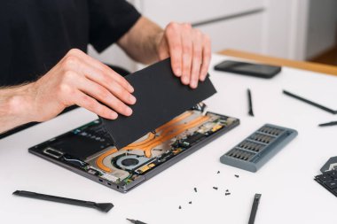 Laptop servis konsepti. Adam evdeki bozuk bilgisayarını tamir ediyor. Bakım süreci, tanı ve kurtarma defteri. Netbook bileşeninde garanti. Aygıt ögelerini yükselt
