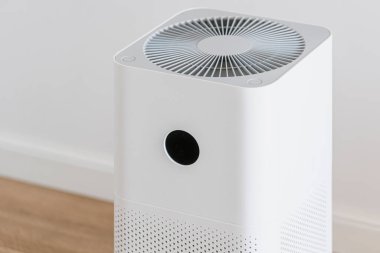 Beyaz yatak odasındaki değiştirilebilir filtreli hava temizleyicisi. Temizlik, toz, alerji kirliliği veya virüs için ev aletleri. Sağlıklı, sağlıklı, rahat bir hayat. Evde nem dağıtıcı var.