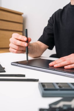Mühendis elinde bir tornavida tutuyor, klavye ya da aküyü değiştirmek için laptop kapağını çıkarıyor. Tamirci bakım için dijital tablet kutusunu söküyor. Garanti hizmeti kavramları