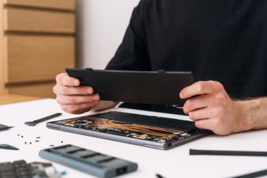 Pil değişimi için temel garanti servisi. Teknisyen dizüstü bilgisayarı onarıp kaldırıyor, eski bileşeni değiştiriyor ve geri dönüştürüyor.