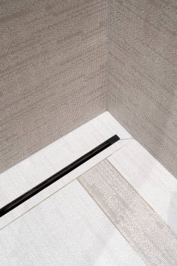 Lüks banyoda fayanslı duvarı olan duş kabininde modern doğrusal akış drenajı. Minimalist tarzda. Su yok etme sistemi. Evdeki tuvalette drenaj..