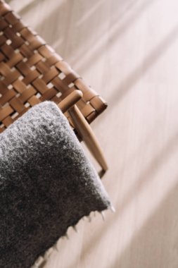 Rahat koltuğun koltuğu üzerinde yumuşak gri ekoseli yüksek açılı manzara. Mobilya tasarlamak ve evde rahat yaşamak için rahat tekstil. Odanın tahta retro sandalyesini kapatın.