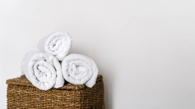 Taze ve yumuşak terry havlular hasır çamaşır sepetinin üstüne katlanmış. Banyo aksesuarları. Ev banyosunda beyaz fotokopi duvarına karşı temiz tekstil. Hijyen kavramı