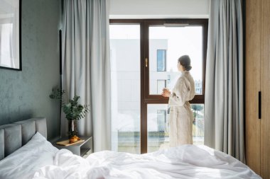 Sıcak yatak odasında sabahları bir fincan kahveyle dikilen bornoz giyen kadın, pencereye bak. Kadın hafta sonunu otelde geçirir, sakin anların tadını çıkarır, akıl sağlığına kavuşur. Basit yaşam konsepti