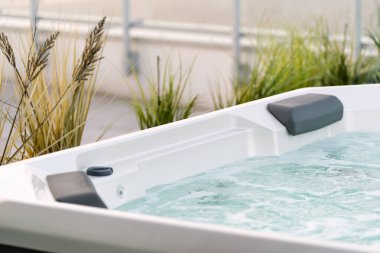 Terasında hidromasaj havuzu olan jakuzi. Şehrin dışında dinlen. Küvetli kulübe. Spa ve sağlık hizmetleri olan bir otel. Güneşli bir yaz günü yeşil bahçede, banyolu.