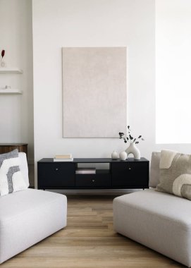 Modern apartmanda minimalist iç tasarımın dikey çekimi. Oturma odasında iki kanepe ya da siyah dolaba karşı koltuklar var. Kanepeler ve vazolar büyük kopya alanının yakınındaki duvarlarda.