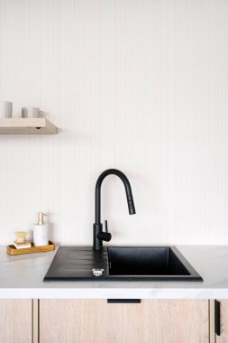 Siyah musluk ve modern lavabo minimalistik mutfak içinde arka planda beyaz fotokopi duvarı, dikey çekim