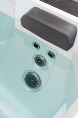 Yüksek açılı jakuzi, başlık ve hidromasaj jeti. Modern küvetin temiz ve şeffaf mavi suyla yakın çekimi. Hidroterapi ve hidro masaj konseptleri.