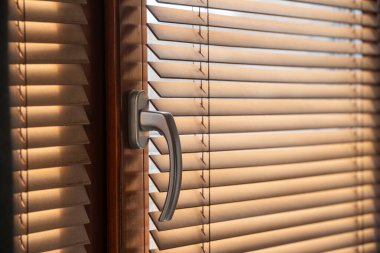 Güneş ışığı, tahtadan yapılmış panjurların arasından hafifçe akar. Gün ışığında sıcak bir odanın içine sıcaklık getirir. Huzurlu ve davetkar bir atmosfer yaratır..