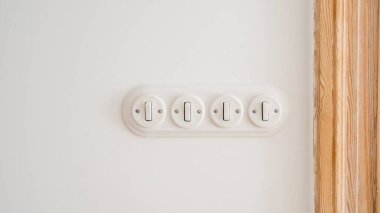 Klasik oturma odasındaki beyaz fotokopi duvarına monte edilmiş yuvarlak çerçeveli ışık anahtarı. Minimalist stil elementlerle dolu bir daire. Enerji verimliliği ve elektrik tasarrufu kavramları