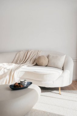 Bu modern yaşam alanı hafif fırlatma ve dekoratif pelüş yastıklarla süslenmiş yumuşak, kıvrımlı bir kanepeye sahiptir. Kahve fincanı ve taze kruvasan otel odasındaki masada, seçici bir odak noktası.