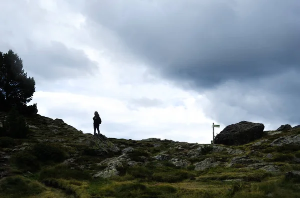 stock image young female hiker backlit on a rocky mountain trail on a cloudy day. she is strong as she enjoys the solitude, silence and freedom on her way.