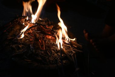 Smoldering wood fire. The fire is being kindled by blowing. Wooden fire. People of village heating fire in cold weather. Rural area in India.