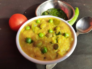 Meşhur Hint yemeği Khichdi servis etmeye hazır. Dal Khichdi kasede servis yaptı. Toovar dal, sebze ve pirinç karışımından yapılmıştır. Rce Khichdi domatesli, yeşil bezelyeli ve biberli, kasede servis ediliyor..