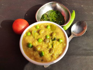 Meşhur Hint yemeği Khichdi servis etmeye hazır. Dal Khichdi kasede servis yaptı. Toovar dal, sebze ve pirinç karışımından yapılmıştır. Rce Khichdi domatesli, yeşil bezelyeli ve biberli, kasede servis ediliyor..