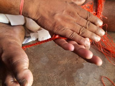 Geleneksel yöntemlerle ip yapan bir adam. Hint köyünde geleneksel halat yapma yöntemi. Bu ip plastik torbalardan yapılıyor..