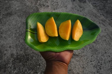 Mango dilimi. Mango aynı zamanda meyvelerin kralı olarak da bilinir. Bu meyve tüm dünyada popüler ve lezzetli bir meyvedir. Mangifera indica 'nın diğer isimleri. Olgun mango.