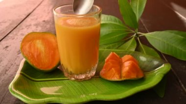 Siyah arka planda izole edilmiş mango dilimli mango suyu. Mango karışımı. Bir bardak taze mango suyu. Bu yazın Hindistan 'ın geleneksel ve en popüler içkisidir..