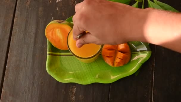 芒果汁与芒果片分离的黑色背景 芒果摇动 一杯新鲜的芒果汁 这是印地安人夏天最受欢迎的传统饮料 — 图库视频影像